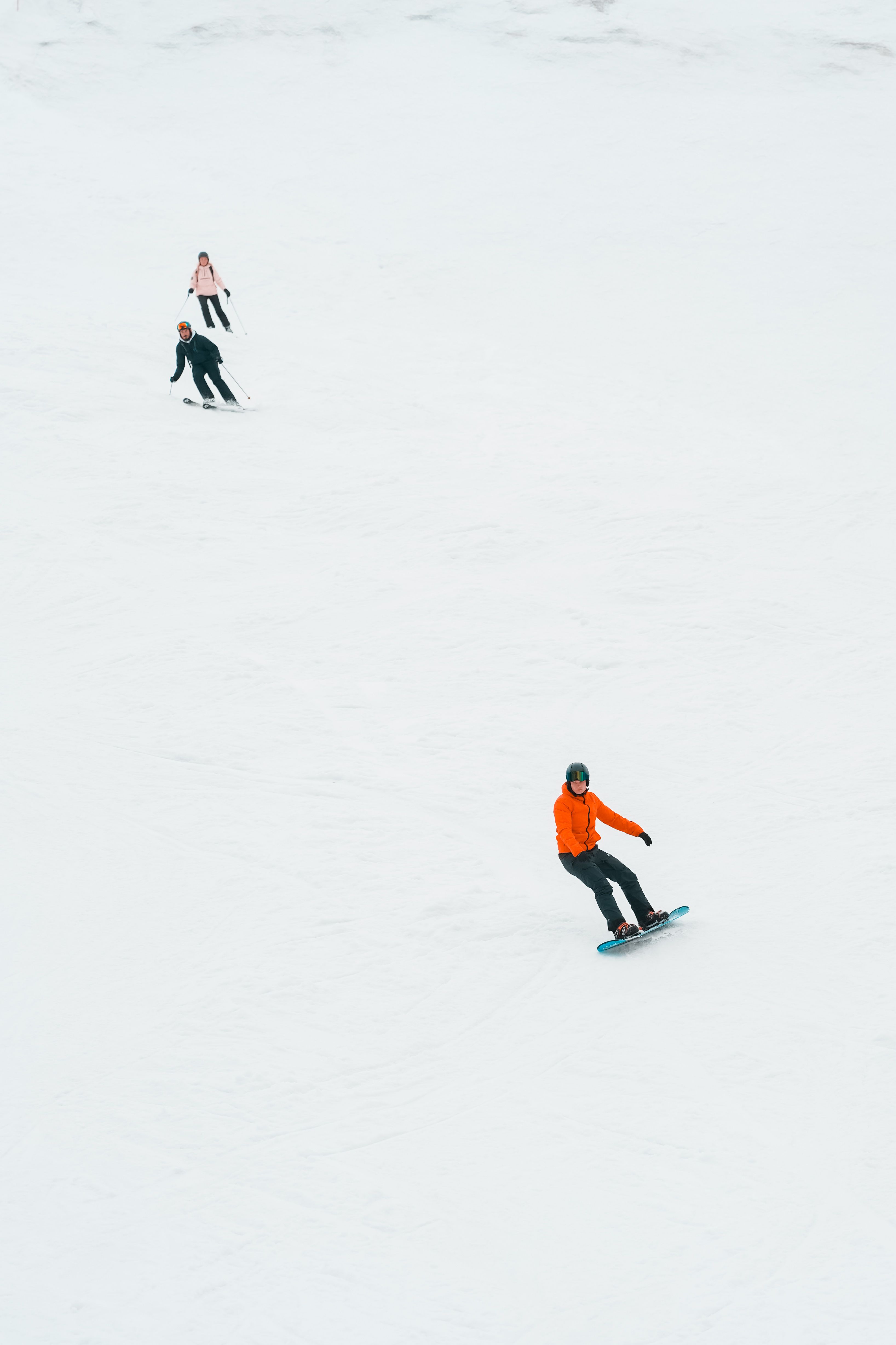Snowboarder riding through a forest tree run