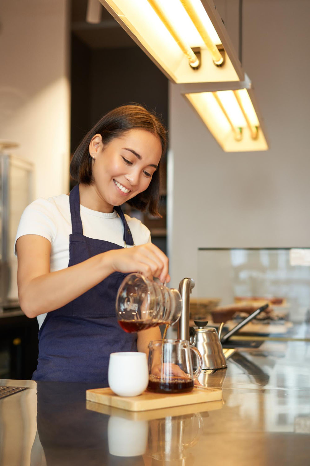 Sandra, manager at Resto Bistro, pouring coffee at the counter
